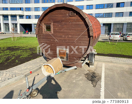 A large round mobile unusual bath or sauna in the form of a trailer for a car in the courtyard of the house for parking A large round mobile unusual bath or sauna in the form of a trailer for a car in the courtyard of the house for parking 77380913