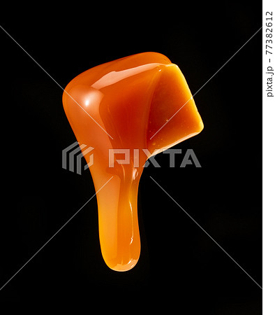 caramel sauce flowing on flying caramel candy caramel sauce flowing on flying caramel candy 77382612