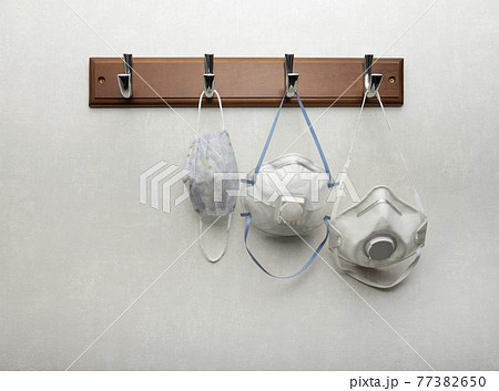 Several respirator masks hanging on clothes rack 77382650
