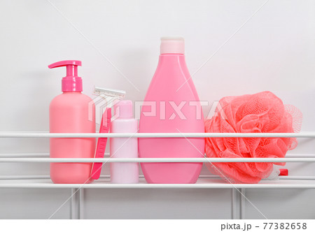 Pink bottles of hygiene toiletries in white bath 77382658