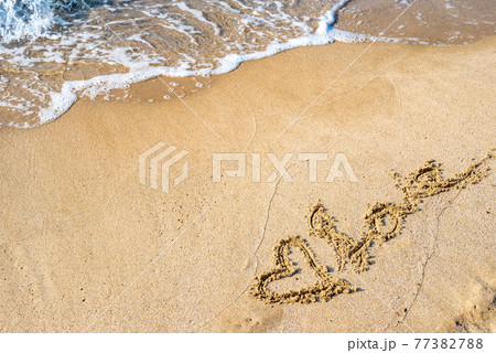 綺麗な海の浜辺の波打ち際に描かれたハートとLOVE　昼間くっきり　背景素材　 77382788