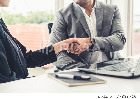 Businessman handshake businesswoman in office. 77383716