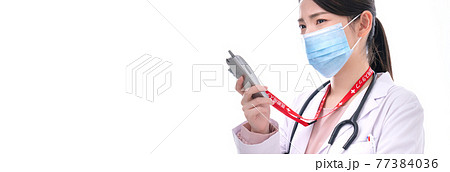 急患の連絡を受ける女性医師 急患の連絡を受ける女性医師 77384036