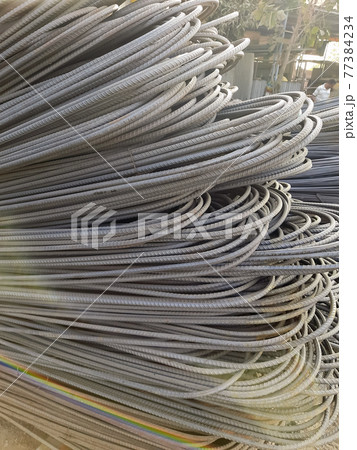 Stack of heavy metal reinforcement bars with periodic profile texture. Close up steel construction armature. Abstract industrial background concept. Copy space. 77384234