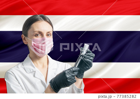 Girl doctor prepares vaccination against the background of the Thailand flag. Vaccination concept Thailand 77385282