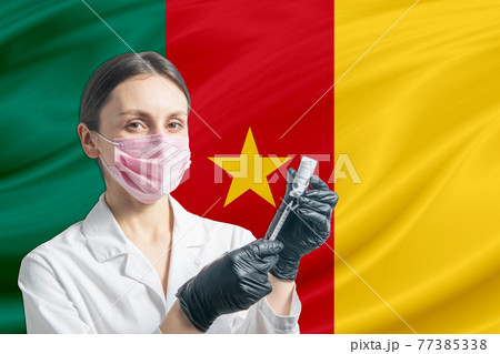 Girl doctor prepares vaccination against the background of the Cameroon flag. Vaccination concept Cameroon Girl doctor prepares vaccination against the background of the Cameroon flag. Vaccination concept Cameroon 77385338