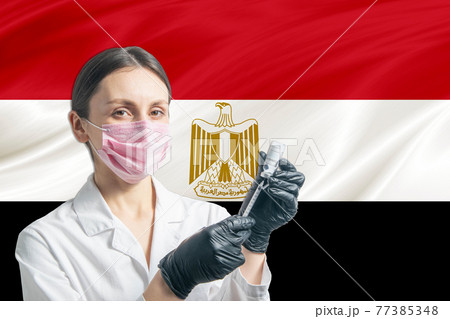 Girl doctor prepares vaccination against the background of the Egypt flag. Vaccination concept Egypt Girl doctor prepares vaccination against the background of the Egypt flag. Vaccination concept Egypt 77385348