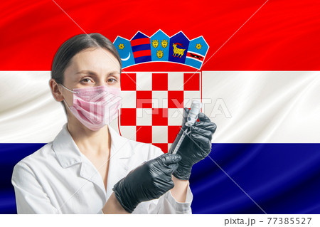 Girl doctor prepares vaccination against the background of the Croatia flag. Vaccination concept Croatia 77385527