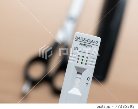 Testing Before Visiting The Hairdresser: Rapid Antigen Corona Test Showing A Negative Result In Front of Scissors and Comb 77385595