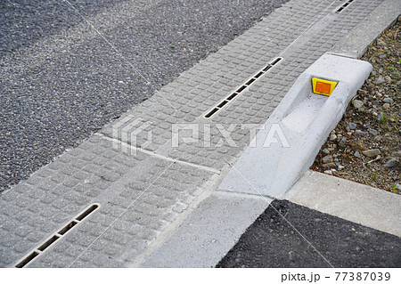 反射板付き歩車道境界ブロック斜め切り下げ型と路面排水スリット側溝のある風景 反射板付き歩車道境界ブロック斜め切り下げ型と路面排水スリット側溝のある風景 77387039
