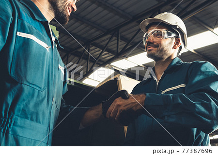 Two skillful factory engineer or worker showing teamwork and partnership . 77387696