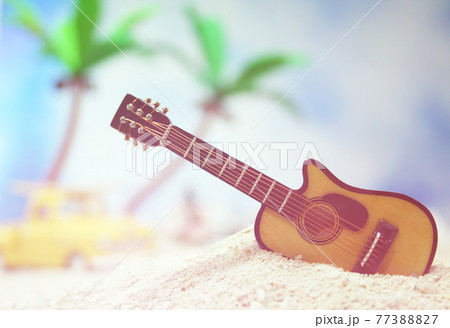 Guitar on Tropical Beach with Vintage Hot Rod in Background 77388827