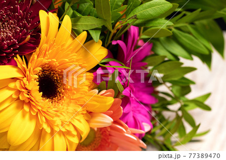 Large beautiful orange gerbera flower in colorful bouquet of flowers. 77389470