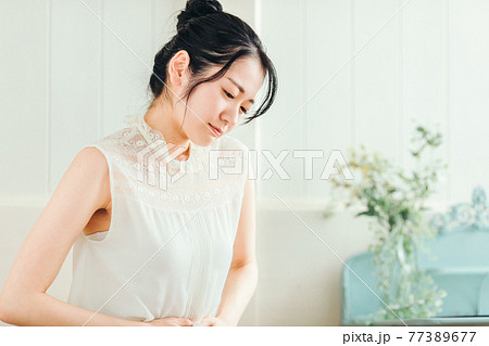 腹痛の女性 77389677