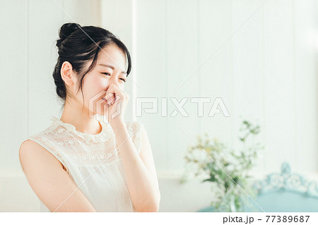 鼻をおさえる女性 鼻をおさえる女性 77389687