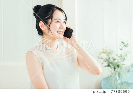 スマホで通話する女性 スマホで通話する女性 77389699