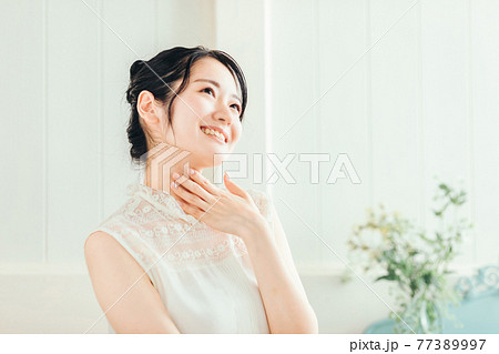 首を触る女性(笑顔) 首を触る女性(笑顔) 77389997