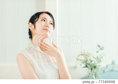 首を触る女性 首を触る女性 77389998