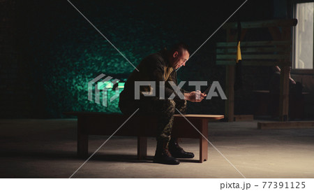 Male soldier making video call in gym Male soldier making video call in gym 77391125