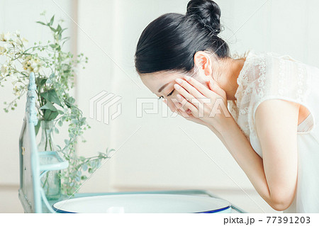 洗顔・スキンケアする女性 77391203