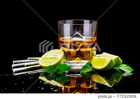 Whiskey with steel cooling cubes on dark glass background Whiskey with steel cooling cubes on dark glass background 77392008