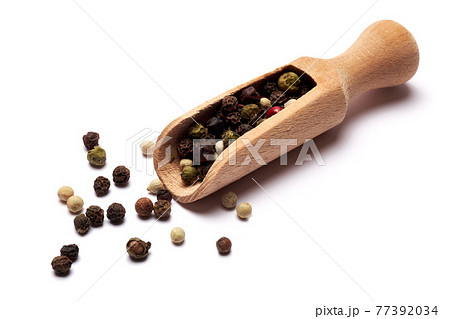 wooden scoop with black round pepper spice on white background 77392034