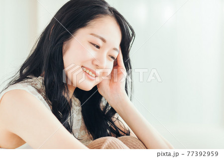 部屋で座っている女性 77392959