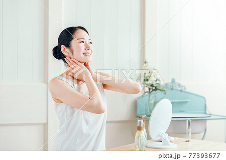 首を触る女性（笑顔） 77393677