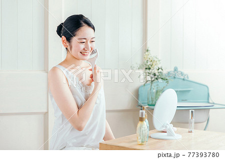 美顔ローラーを使う女性(笑顔) 美顔ローラーを使う女性(笑顔) 77393780