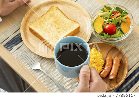 朝食を食べる男性　コーヒー 77395117