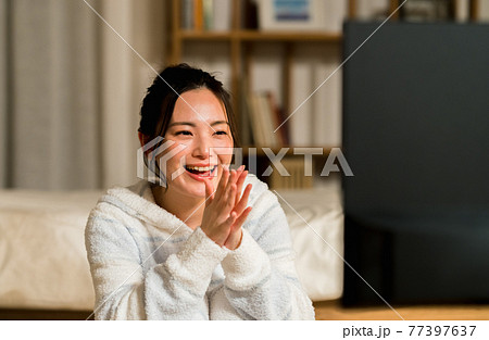 部屋でテレビを見る若い女性 部屋でテレビを見る若い女性 77397637