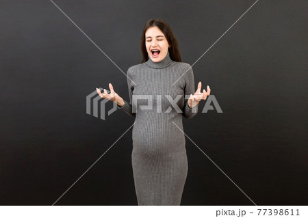 Young beautiful teenager girl pregnant expecting baby over isolated colored background, aggressive expression and arms raised. Frustration concept Young beautiful teenager girl pregnant expecting baby over isolated colored background, aggressive expression and arms raised. Frustration concept 77398611