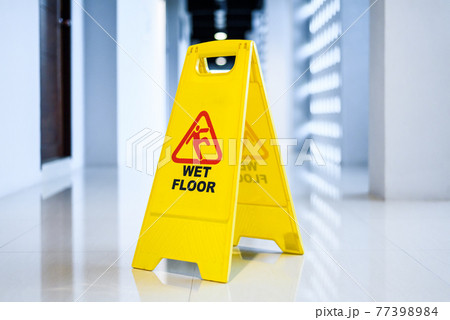 Sign showing warning of wet floor on wet floor 77398984