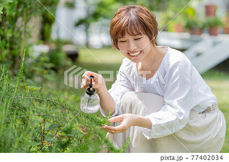 庭で植物の手入れをする若い女性 ガーデニング 庭で植物の手入れをする若い女性 ガーデニング 77402034