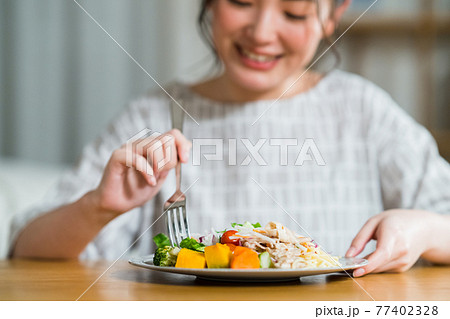 夕食を食べる若い女性 77402328
