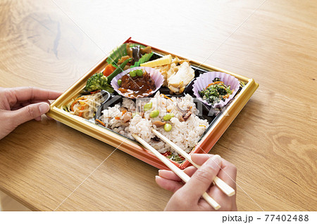 コンビニ弁当を食べる女性の手元 コンビニ弁当を食べる女性の手元 77402488