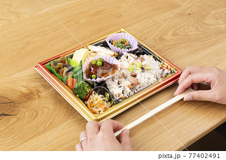 コンビニ弁当を食べる女性の手元 77402491
