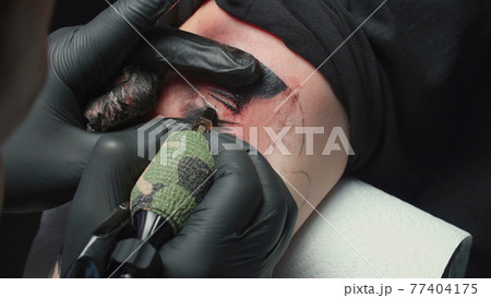 Man tattooist getting tattoo of snake, closeup Man tattooist getting tattoo of snake, closeup 77404175
