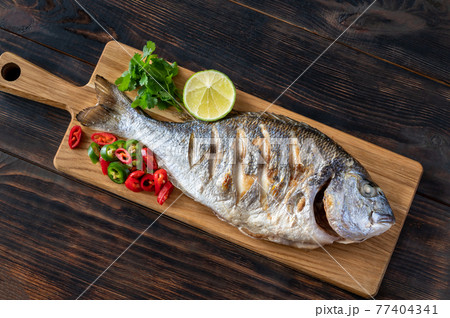 Grilled fish on the wooden board Grilled fish on the wooden board 77404341