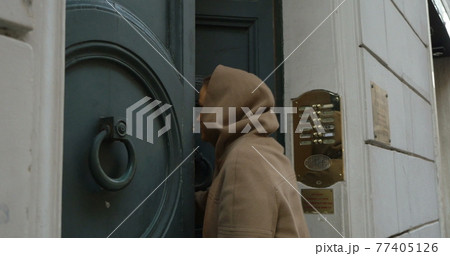 Woman opening entrance door and coming in 77405126