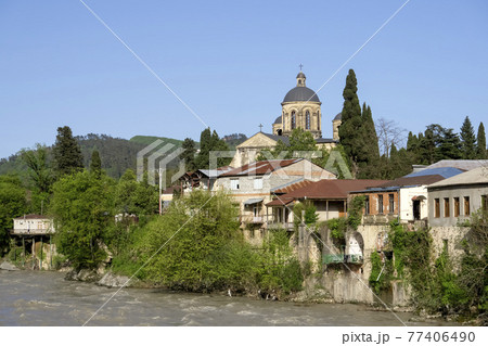 Kutaisi Georgia. Landscape and panorama of the Georgian city of Kutaisi with a Christian church and houses on the river bank. Sightseeing, tourism and travel in Georgia 77406490