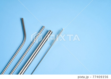The modern trend towards caring for the environment. Kit of reusable metal beverage straws of various diameters with cleaning tool 77409356
