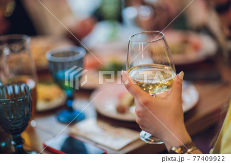 Clinking glasses with alcohol and toasting, party. 77409922