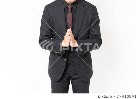 白背景の前に立って、謝罪する男性ビジネスマン 77410941