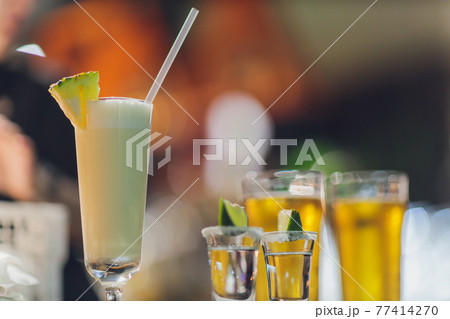 Two shots of tequila and a pair of lemon pieces. 77414270