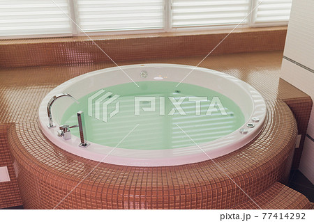 jacuzzi bath tub on marble floor with water. jacuzzi bath tub on marble floor with water. 77414292