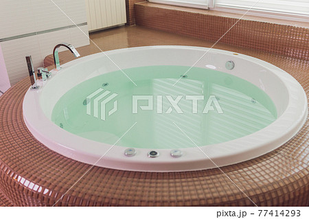 jacuzzi bath tub on marble floor with water. 77414293