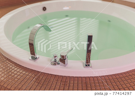 jacuzzi bath tub on marble floor with water. 77414297