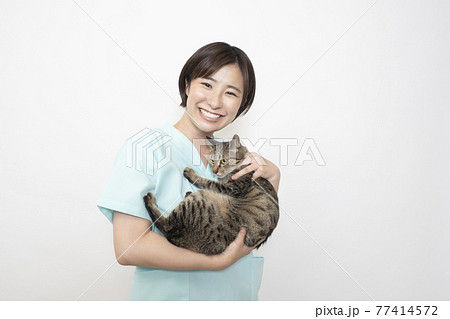 猫を抱く女性獣医師 77414572
