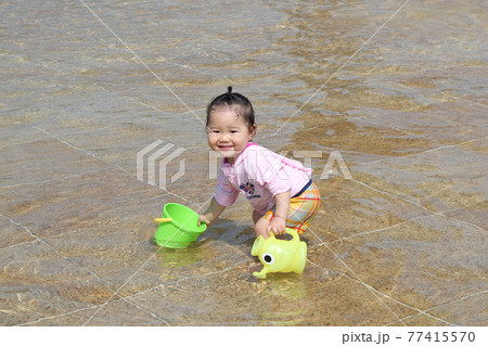 バケツとジョーロで水遊びをする子どもの写真素材